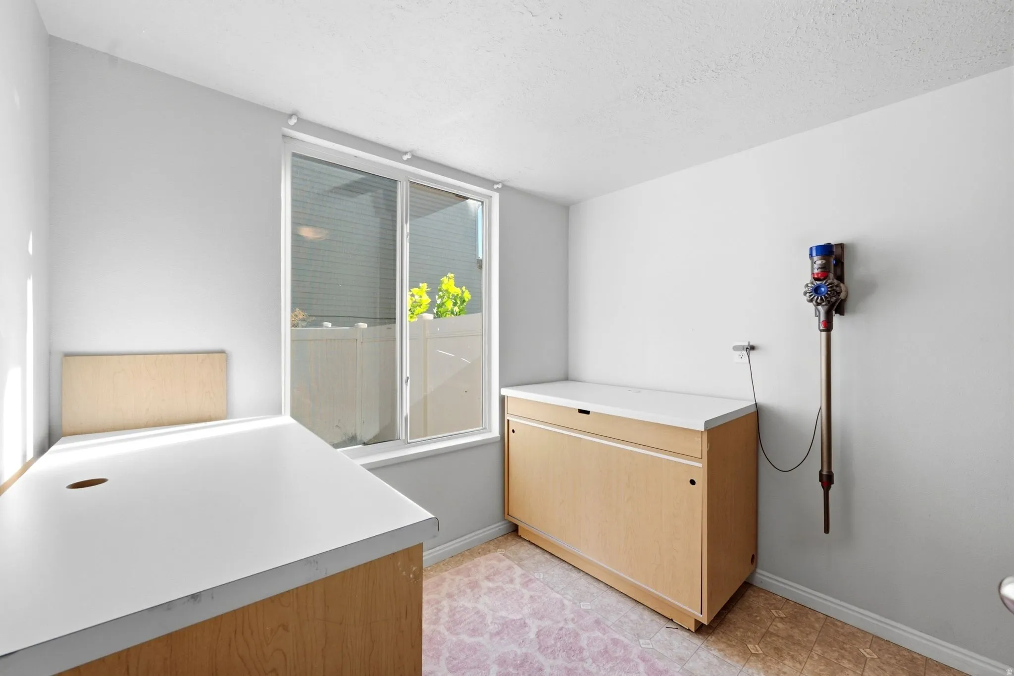 Dual-pane window, built-in desk with a white surface, and an additional built-in cabinet with a white surface