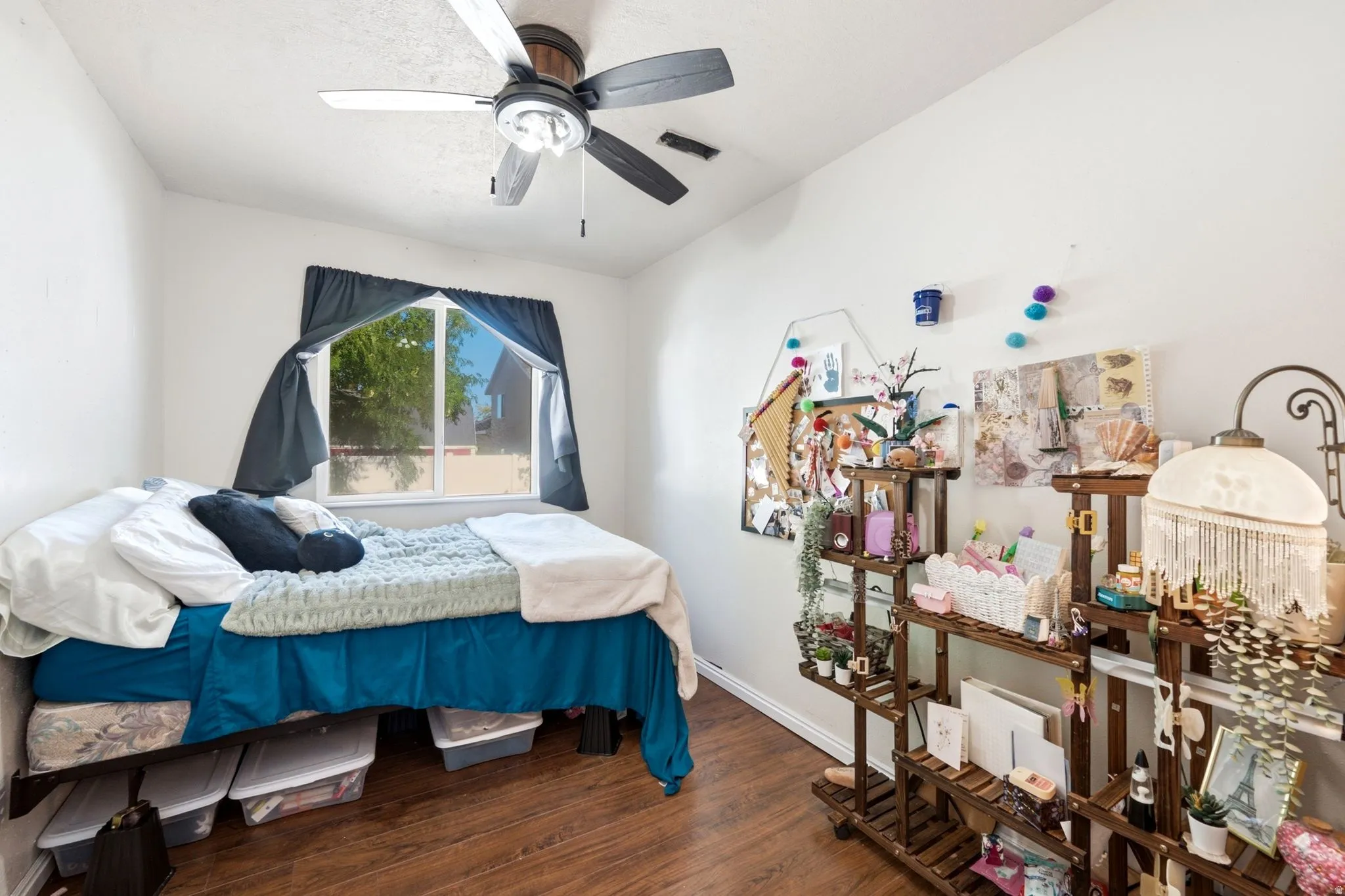 Wood-finish flooring with a ceiling fan and overhead lighting