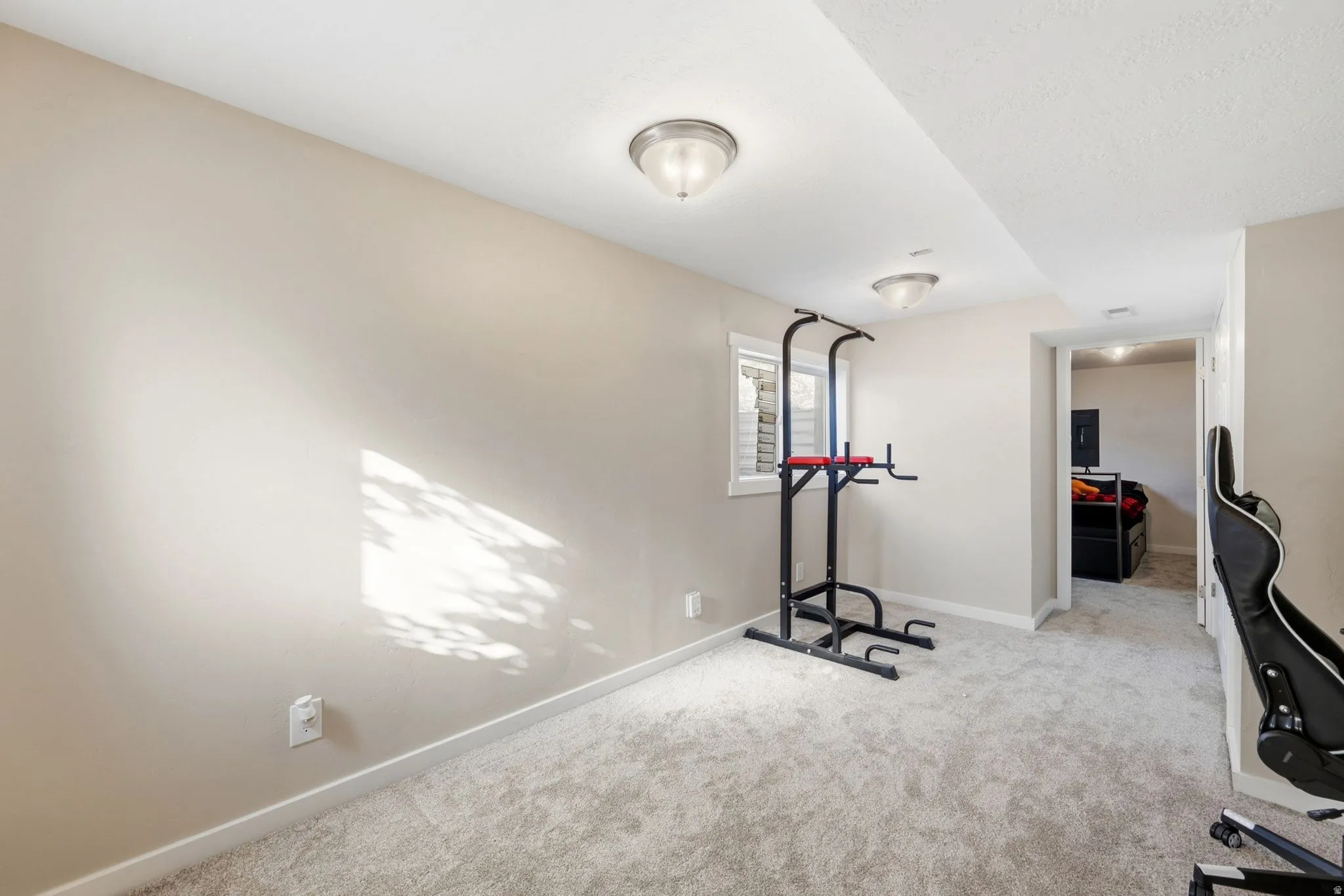 Recessed window with white blinds, neutral wall paint, and light gray carpeting