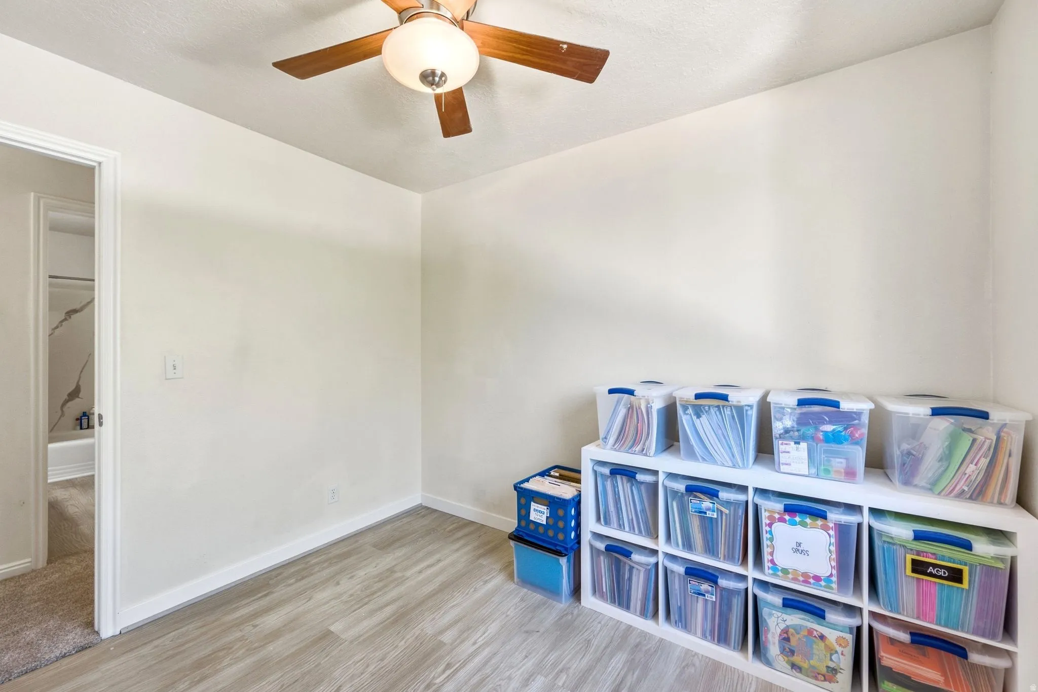 Recessed ceiling fan with light fixture, wood-finish flooring, and light-toned wall paint