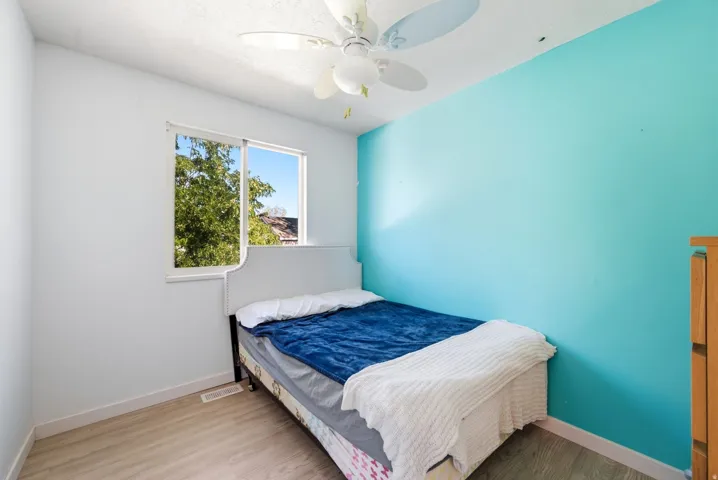 Recessed window with white trim, wood-finish flooring, and ceiling fan