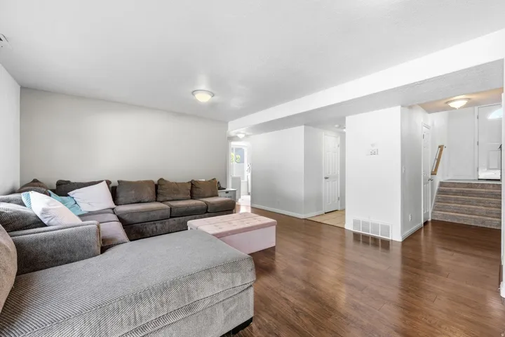 Spacious room featuring wood-finish flooring, white walls, and flush-mount lighting