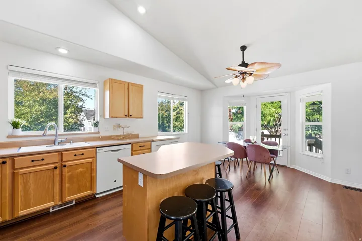 Kitchen with wood-finish flooring, light wood cabinetry, and a central island