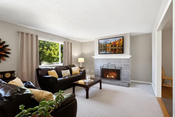 Tile-surround fireplace with a white mantel, light gray wall paint, and light-colored carpeting