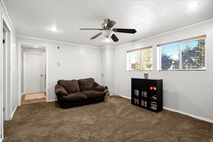 Plush carpet flooring, multiple windows, a ceiling fan with integrated lighting, and recessed ceiling lights