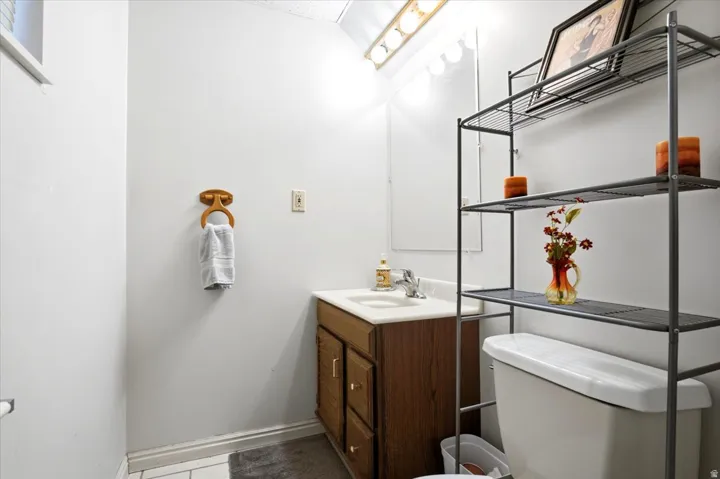 Vanity with wood-finish cabinetry, integrated sink, and chrome faucet