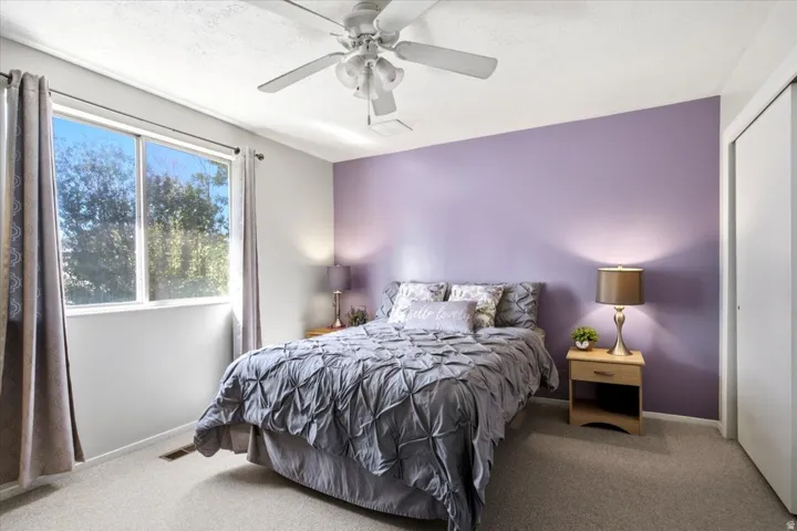 Carpeted flooring, ceiling fan, dual-pane window, and built-in closet with sliding doors