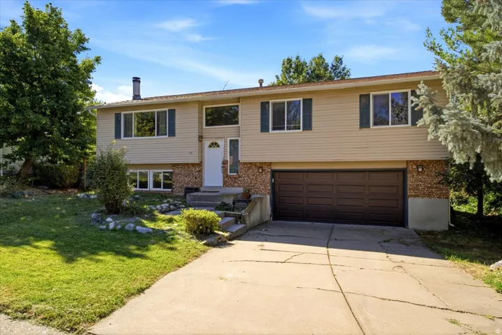 Split-level residence featuring brick and siding exterior, an attached two-car garage, and a concrete driveway