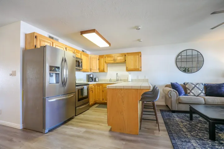Kitchen featuring wood-finish cabinetry, stainless steel appliances, and a tiled countertop