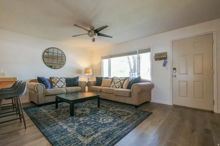 Recessed lighting, wood-finish flooring, ceiling fan, and large window with blinds