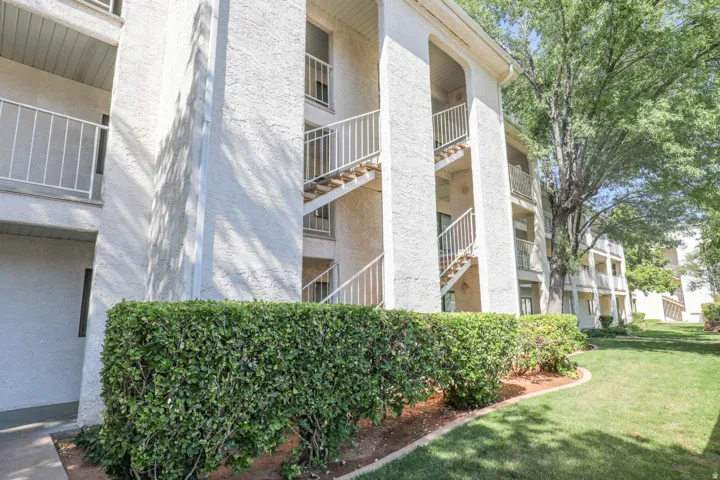 Exterior building featuring textured stucco walls, multiple balconies with metal railings, and external staircases