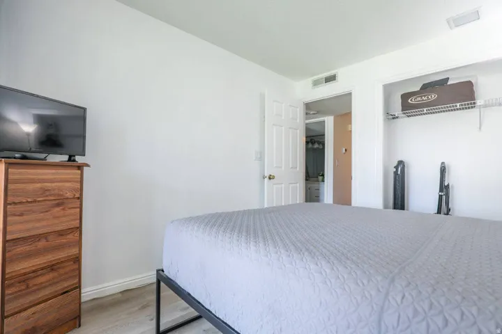 Light-toned wood-finish flooring, white walls, and a built-in closet with wire shelving