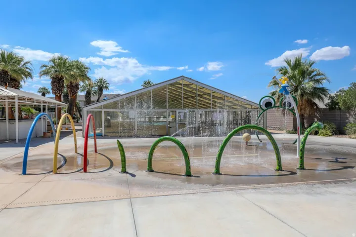 Splash pad with colorful water features and a playful frog-themed spray