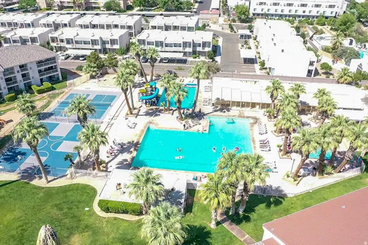 Multiple swimming pools, tennis courts, a basketball court, and mature palm trees