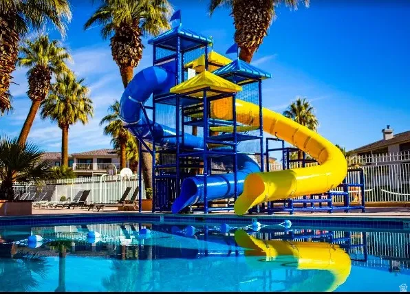 Swimming pool with a slide structure featuring blue and yellow slides