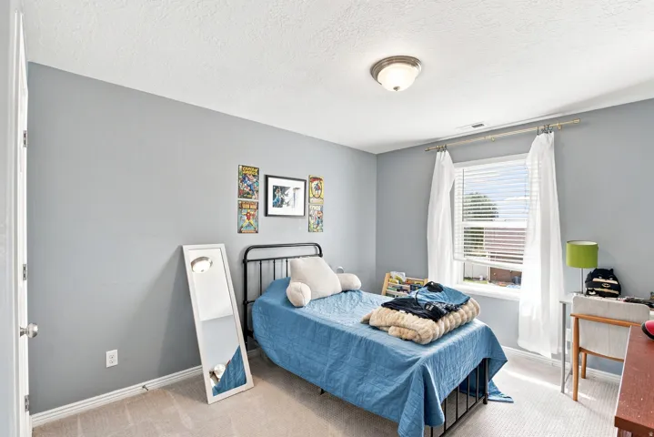 Neutral wall color, carpeted flooring, window with blinds, and flush-mount ceiling light fixture