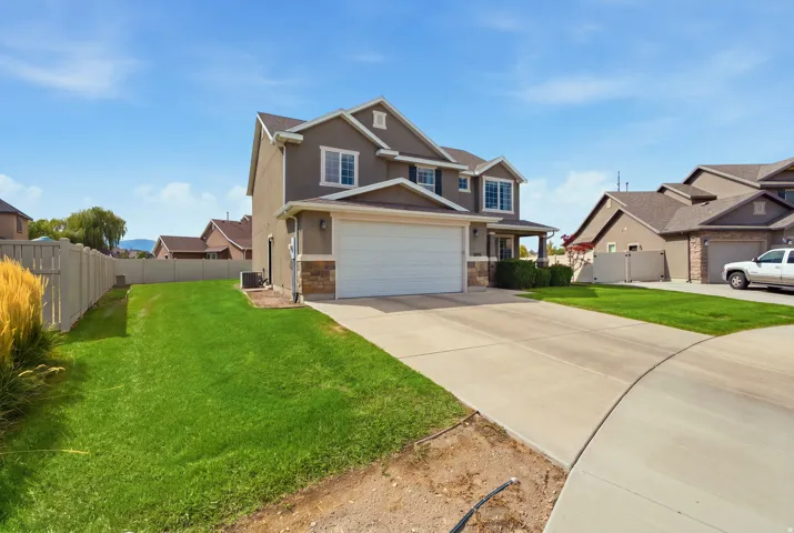 Two-story stucco and stone-accented exterior with a two-car garage
