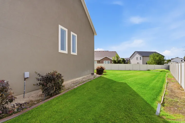Expansive grassy lawn with a privacy fence