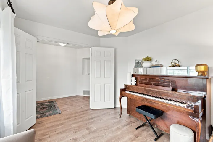 Wood-finish flooring, white walls, and a modern ceiling light fixture