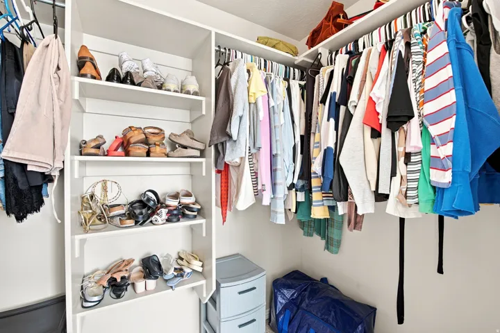 Built-in shelving with multiple levels, hanging garment rods, and corner configuration