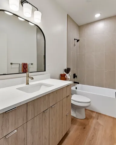 Integrated vanity with wood-finish cabinetry, white countertop, and undermount sink