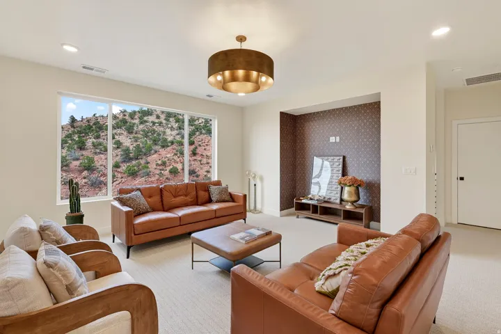 Expansive window overlooking a natural landscape, recessed lighting, and a decorative ceiling fixture