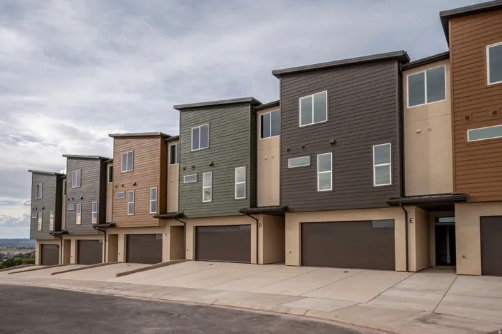 Contemporary multi-level townhomes featuring varied siding finishes and attached garages