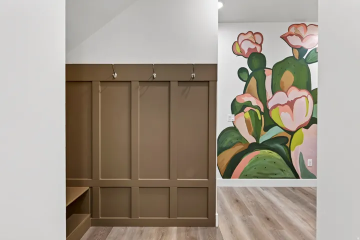 Built-in board and batten wall paneling with integrated hooks and bench storage