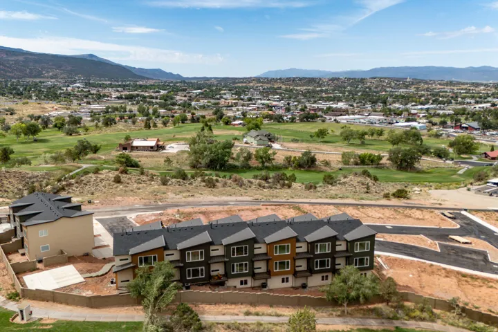 Modern multi-level townhomes with pitched dark gray roofs and private balconies