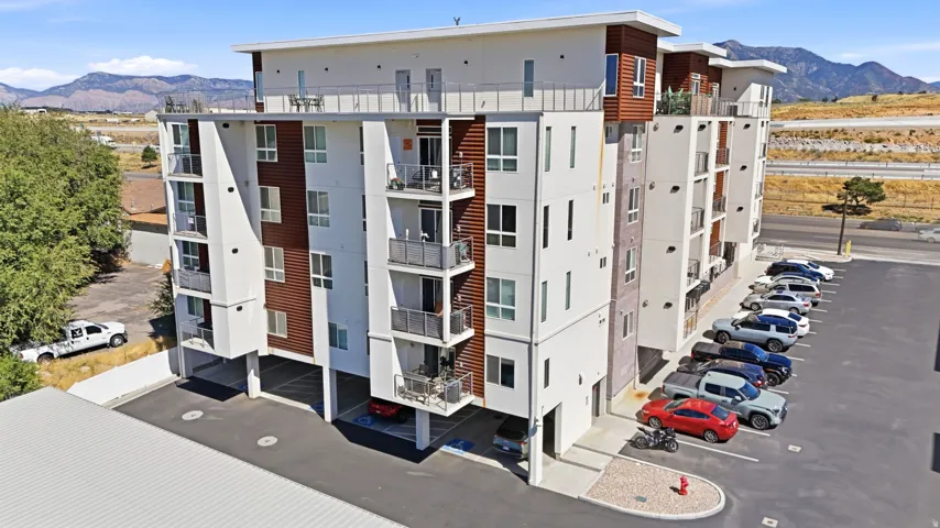 Multi-story building featuring balconies, white exterior finishes, and wood-finish accents