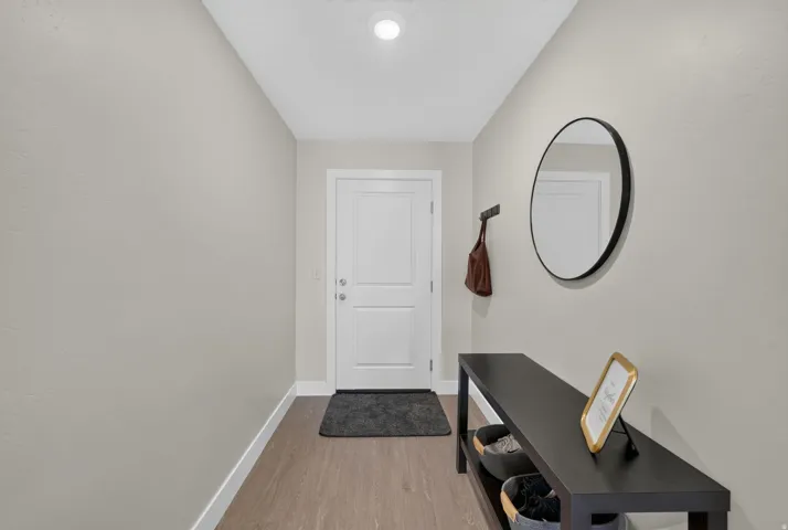 Recessed ceiling lighting, wood-finish flooring, and a two-panel entry door