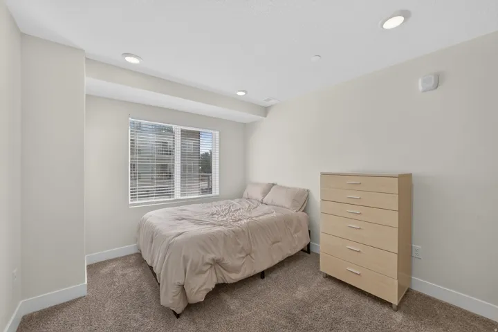 Recessed ceiling lighting, window with blinds, and carpeted flooring