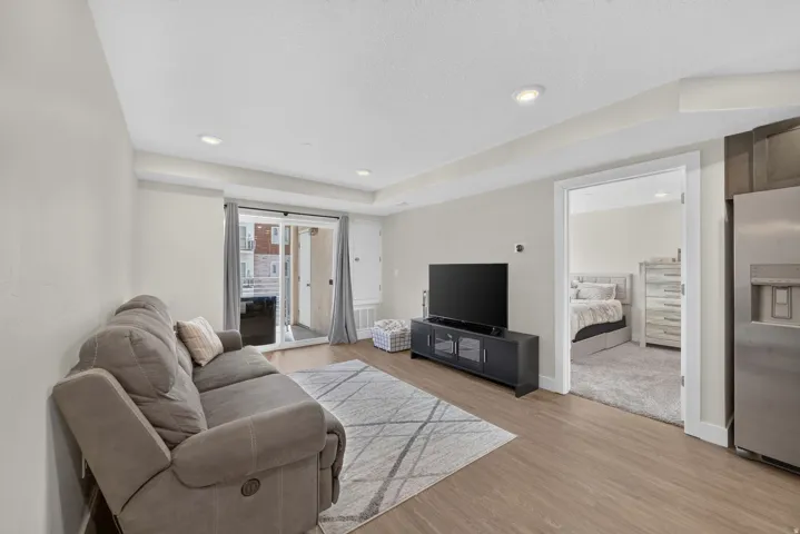 Wood-finish flooring throughout, recessed lighting, and a sliding glass door