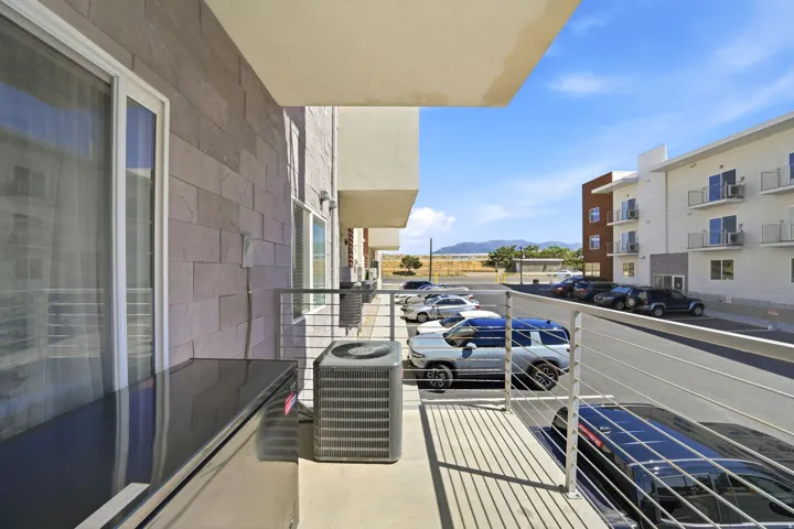 Private balcony with stainless steel railing, solid surface countertop, and sliding glass door access
