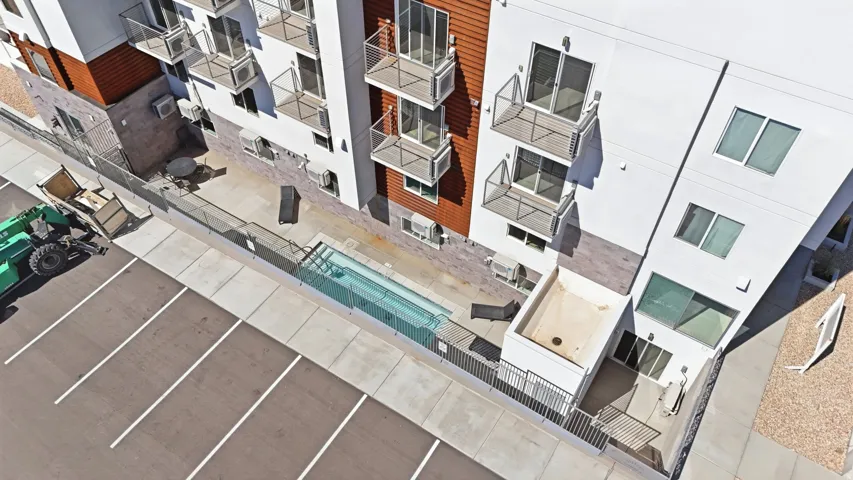 Modern building exterior with white and wood-tone facade elements featuring the Pool