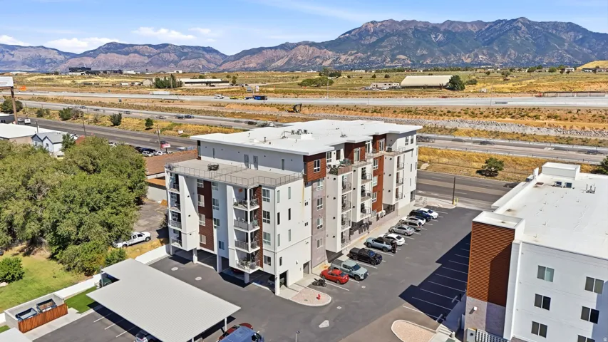 Modern multifamily property featuring a multi-story design, attached balconies, and a surface parking lot