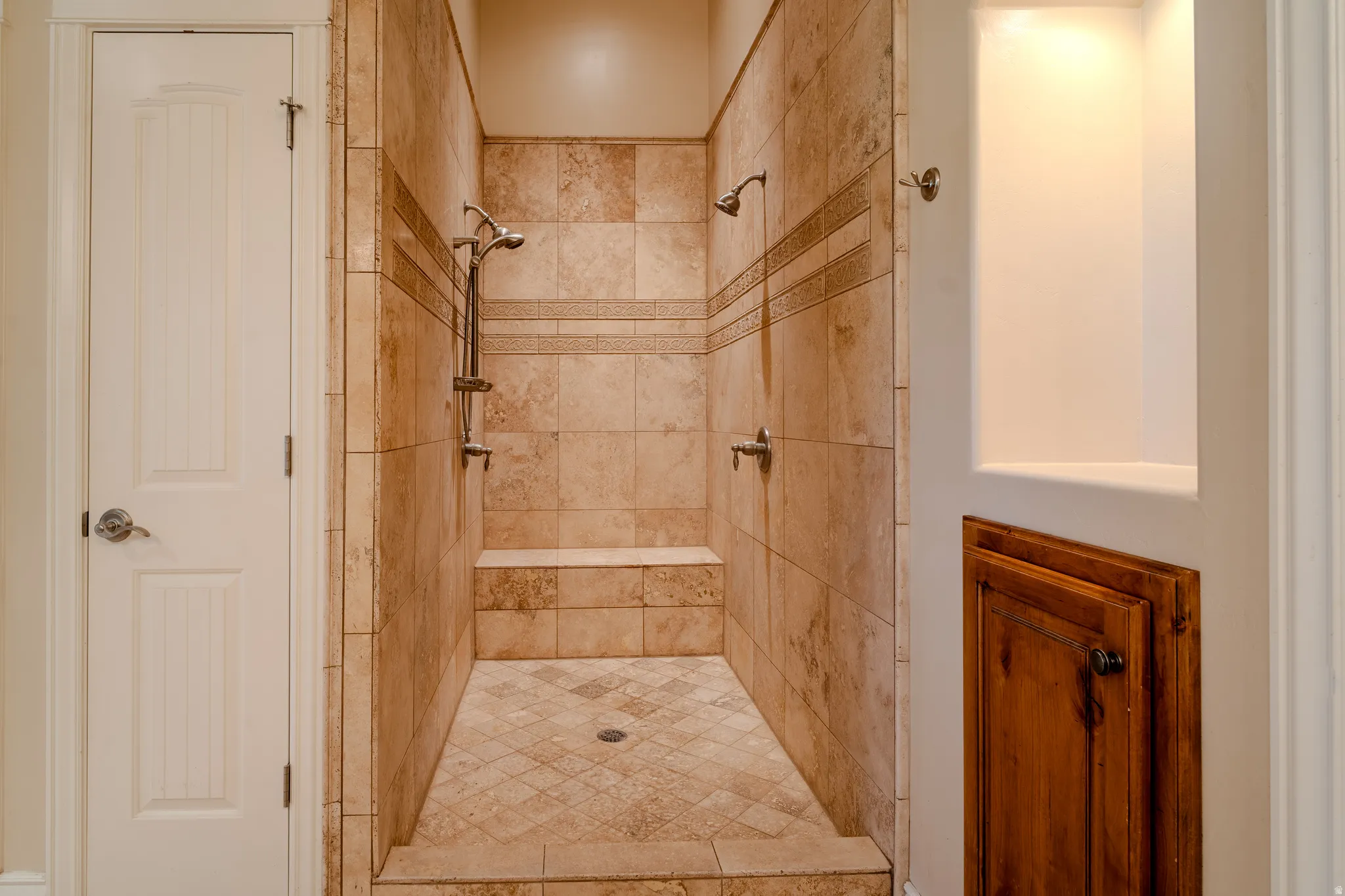 Tiled walk-in shower with integrated bench and dual showerheads