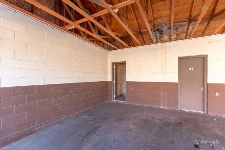 Exposed wood beam ceiling with concrete block walls and two entry doors