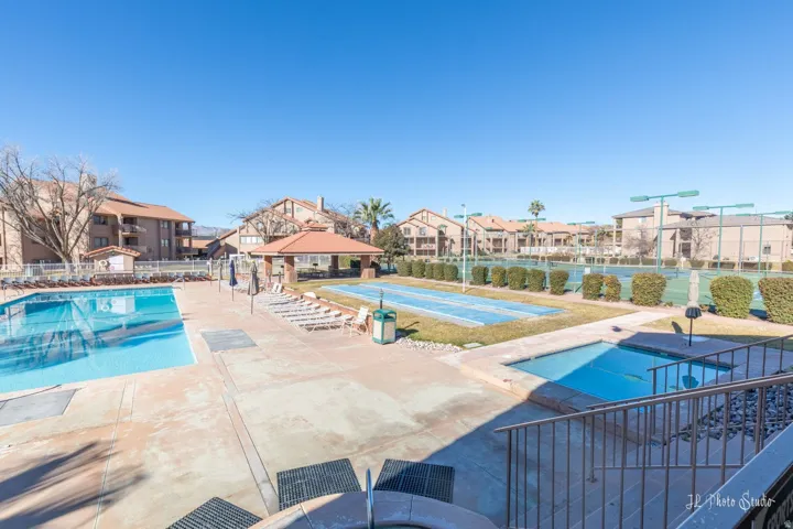 Outdoor swimming pool, separate spa, covered patio, shuffleboard court, and tennis courts