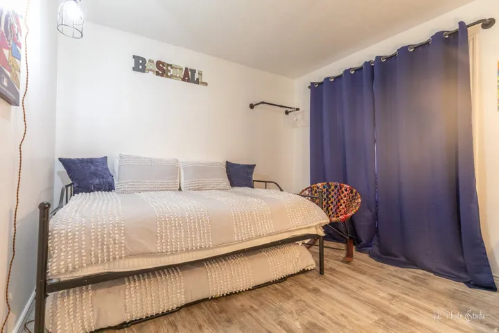 Wood-finish flooring with white walls and a ceiling-mounted light fixture