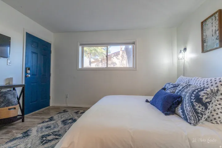 White interior walls, wood-finish flooring, built-in window, and a wall-mounted light fixture