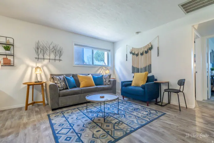 Recessed ceiling lighting, wood-finish flooring, white walls, and a large window