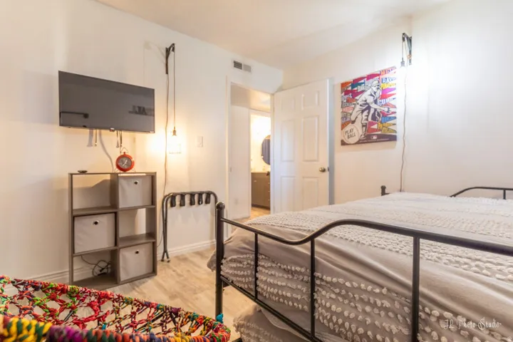 White paneled interior door, light wood-finish flooring, and wall-mounted lighting fixtures