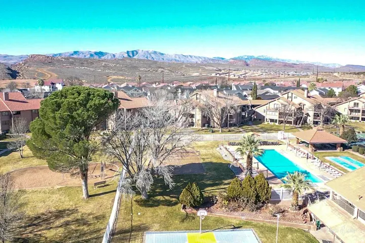 Community featuring a large outdoor pool, shaded cabana, sports court, and open green spaces