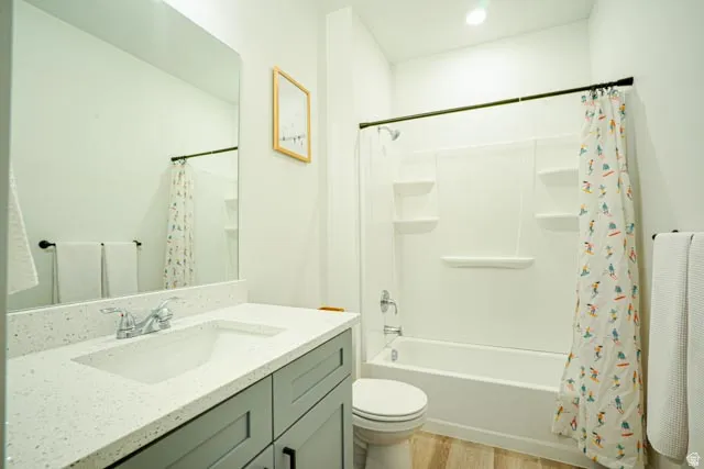 Bathroom featuring a vanity with a white speckled countertop, an integrated sink, and a large wall-mounted mirror