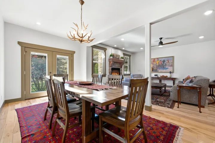 Hardwood flooring throughout, recessed lighting, double French doors, antler-motif chandelier, and a stone-clad fireplace