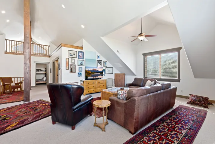 Vaulted ceilings, exposed wood beam, recessed lighting, ceiling fan, and window with blinds