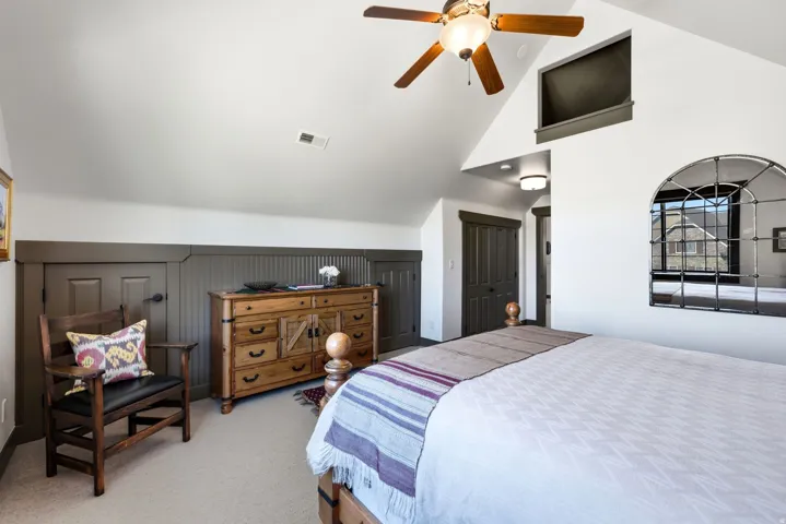 Vaulted ceiling with a ceiling fan, recessed lighting, and wall paneling