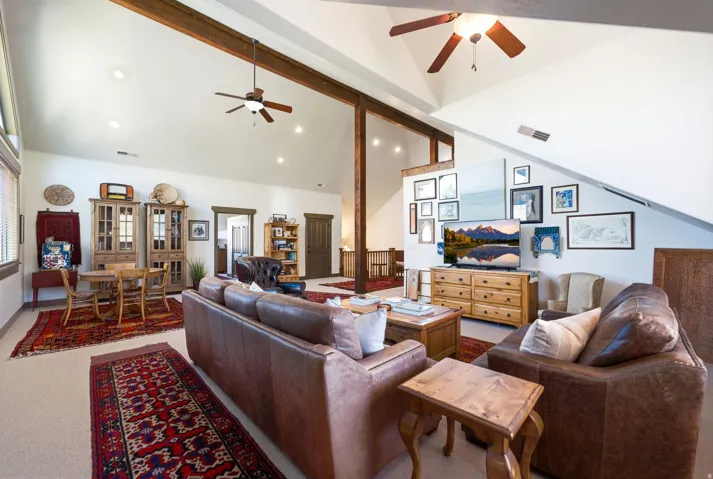 Vaulted ceilings with exposed wood beams, recessed lighting, and ceiling fans