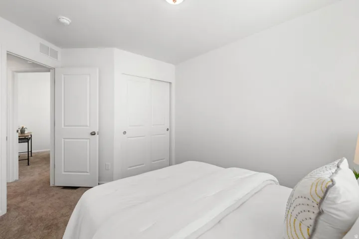 White walls with textured finish, carpeted flooring, and a ceiling light fixture